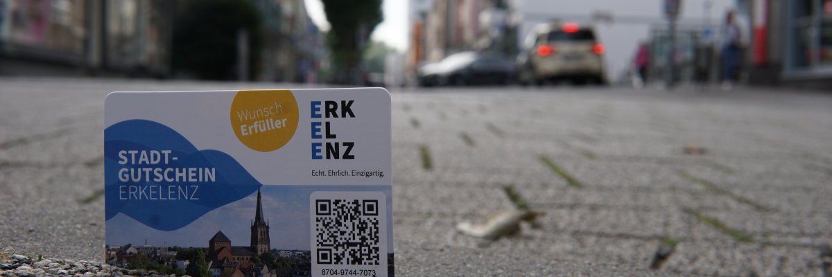 Foto des Erkelenzer Stadtgutscheins, im Hintergrund die Kölner Straße