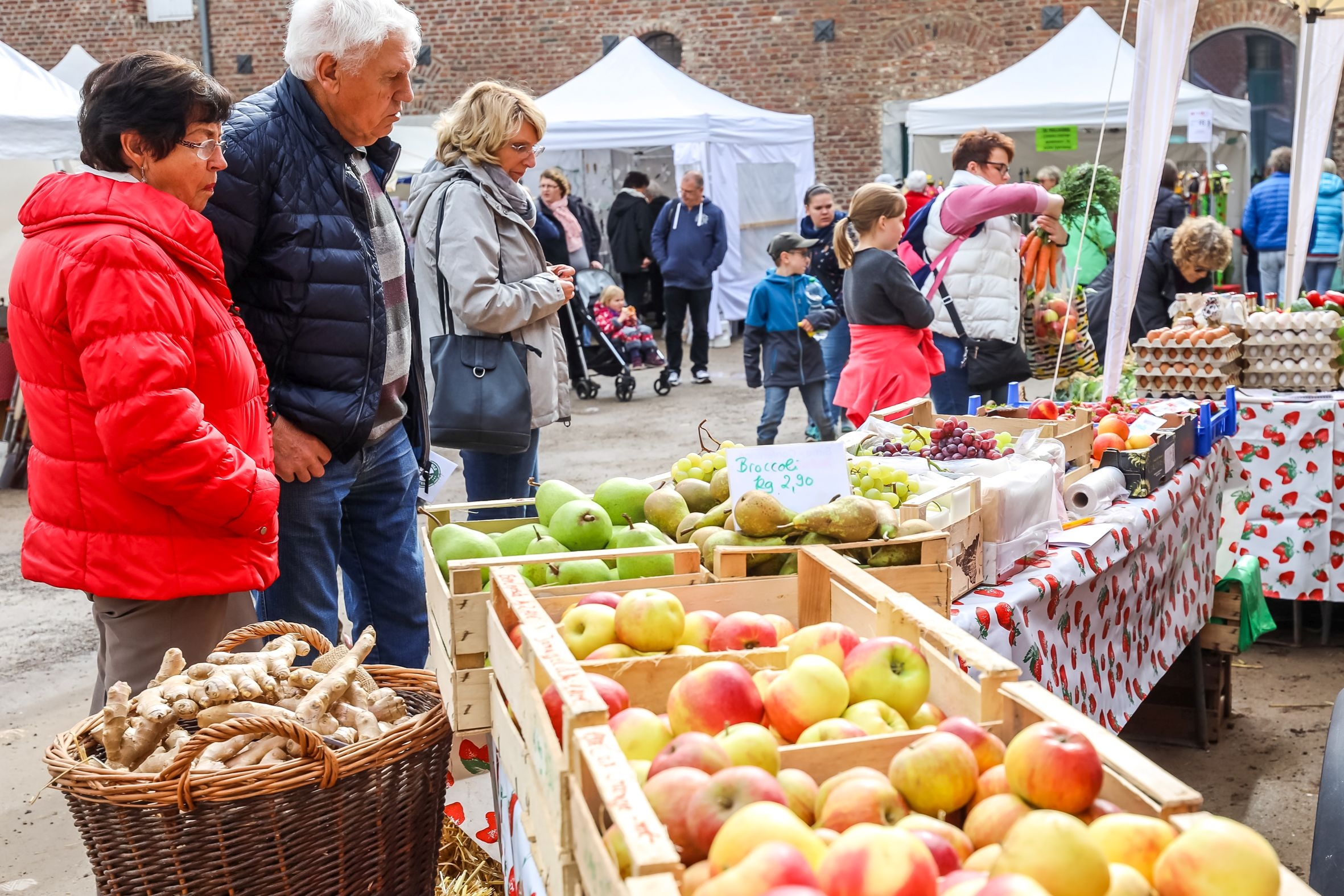 Besucherinnen und Besucher an einem Verkaufsstand beim Bauernmarkt auf Haus Hohenbusch