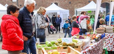 Besucherinnen und Besucher an einem Verkaufsstand beim Bauernmarkt auf Haus Hohenbusch