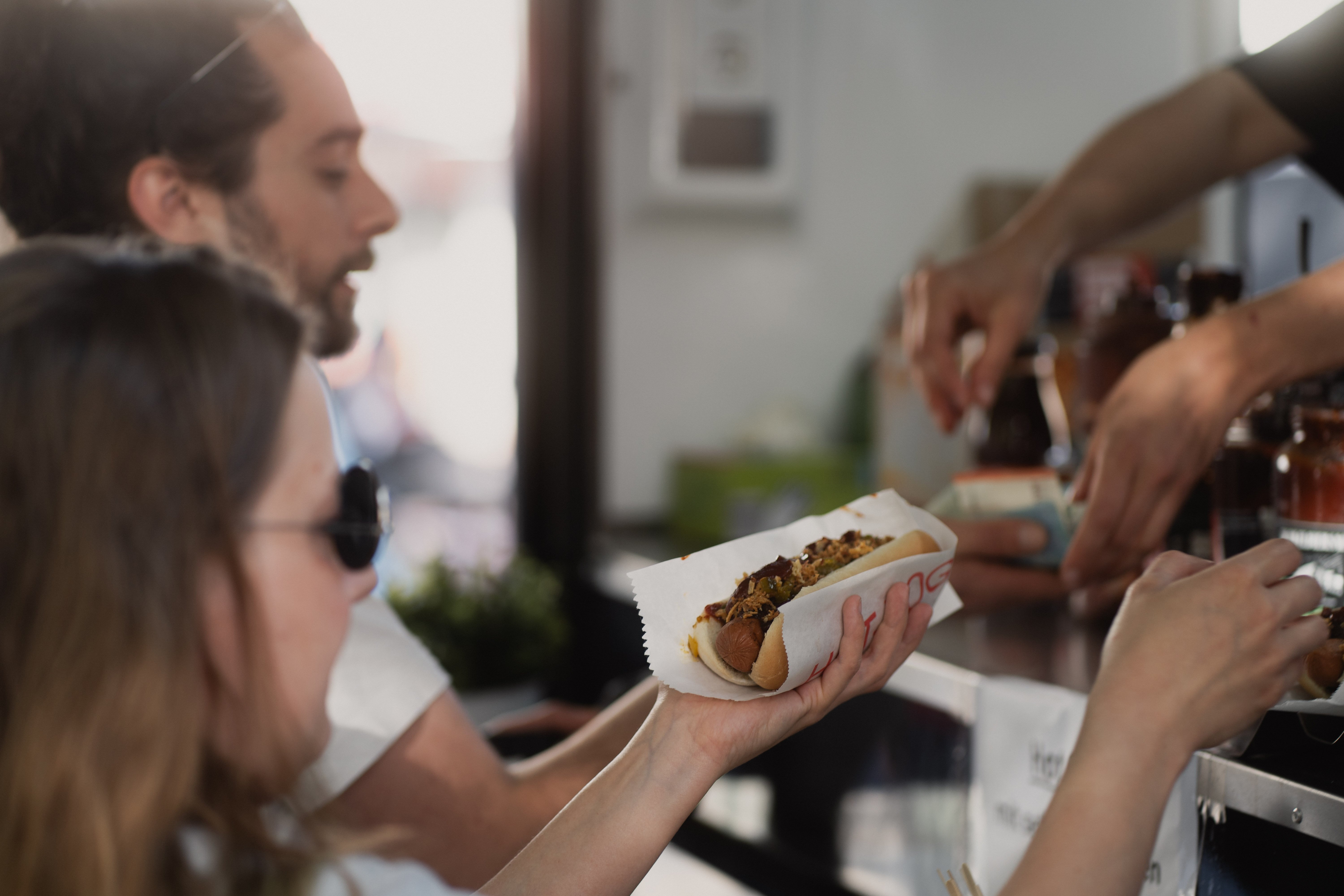 zwei Personen kaufen einen Hotdog
