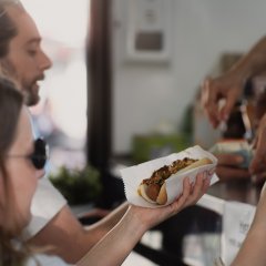 zwei Personen kaufen einen Hotdog