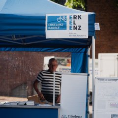 eine Person steht hinter einem Infostand