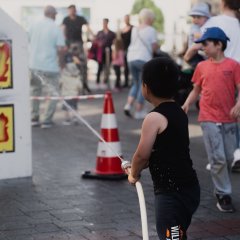 Kinder halten einen Feuerwehrschlauch