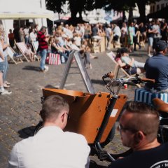 Gäste beim Bike'n'BBQ. Im Vordergrund steht ein Lastenfahrrad.