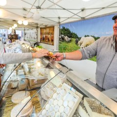 Eine Person kauft Käse beim Französischen Markt