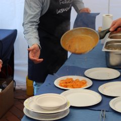 Tortellini werden auf einem Teller angerichtet.