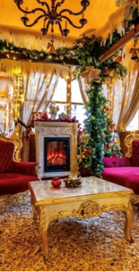 Ein festlich geschmückter Raum mit roten Sesseln und Weihnachtsdekoration.