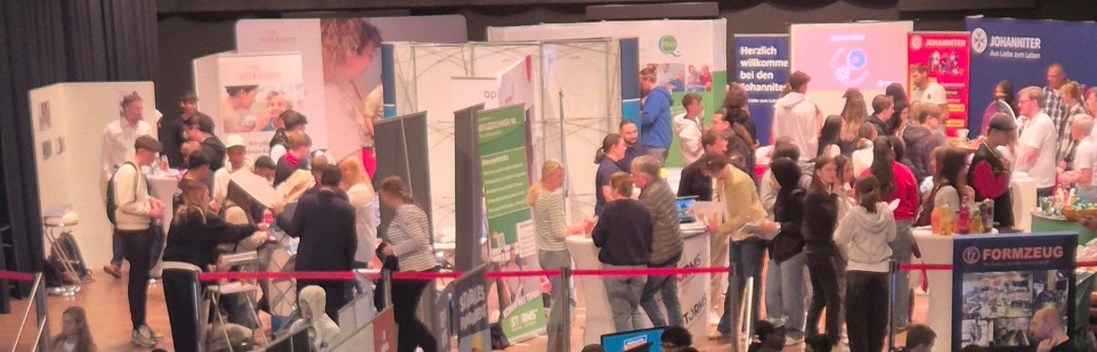 Menschenmenge auf einer Messe mit Ständen.