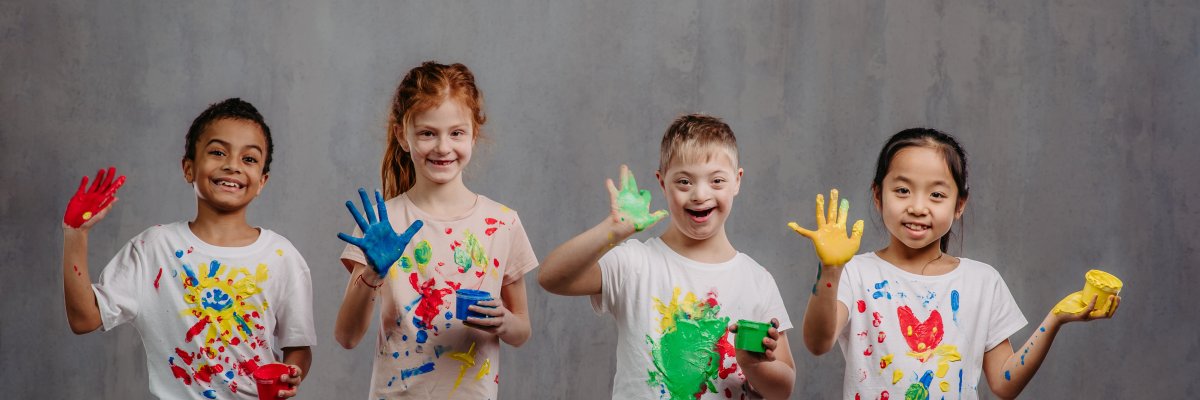 Portrait of happy kids with finger colours and painted t-shirts, studio shoot.