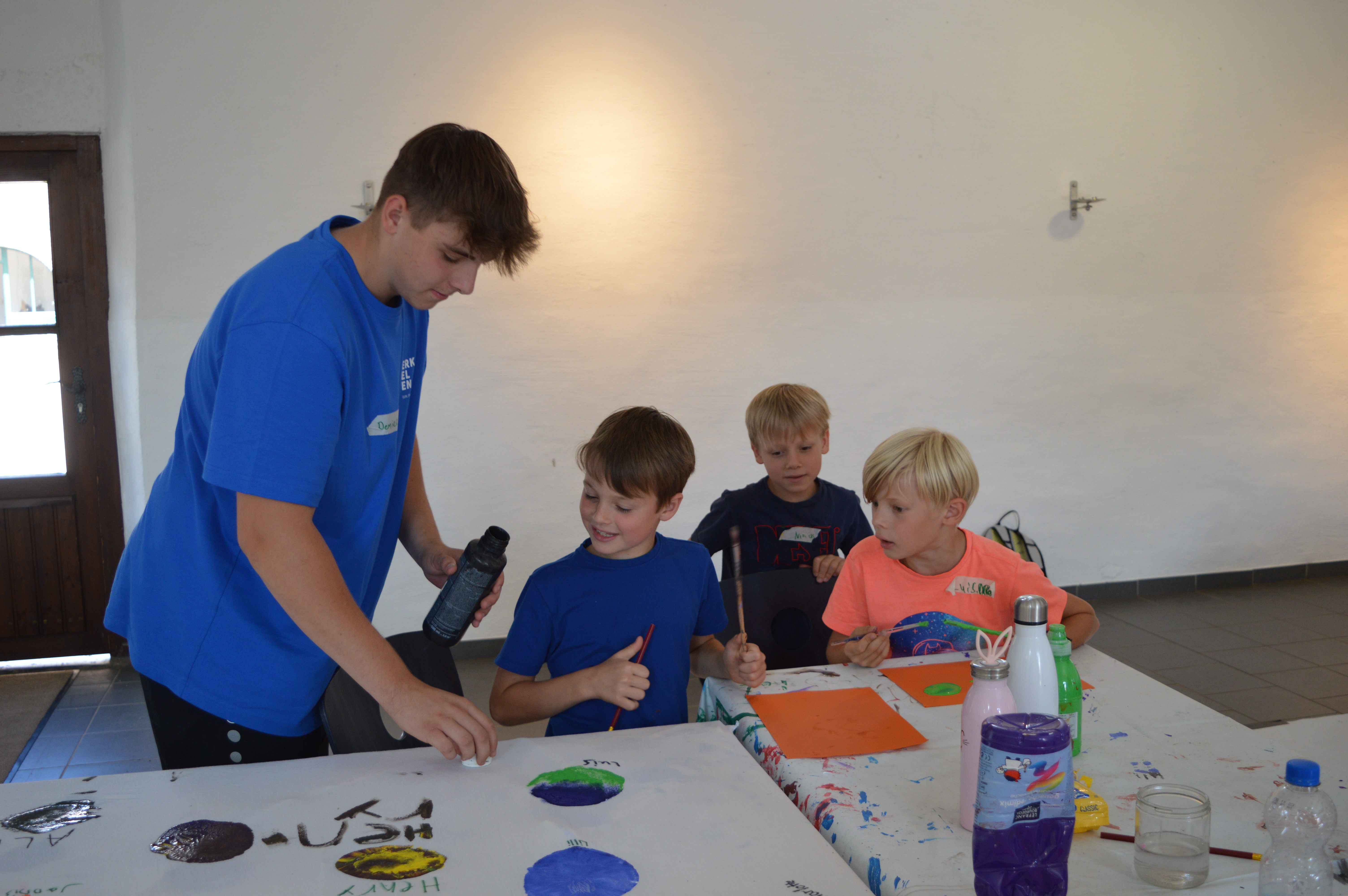 Teamer hilft Kindern beim Basteln