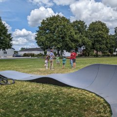 Pumptrackanlage mit Kindern im Hintergrund