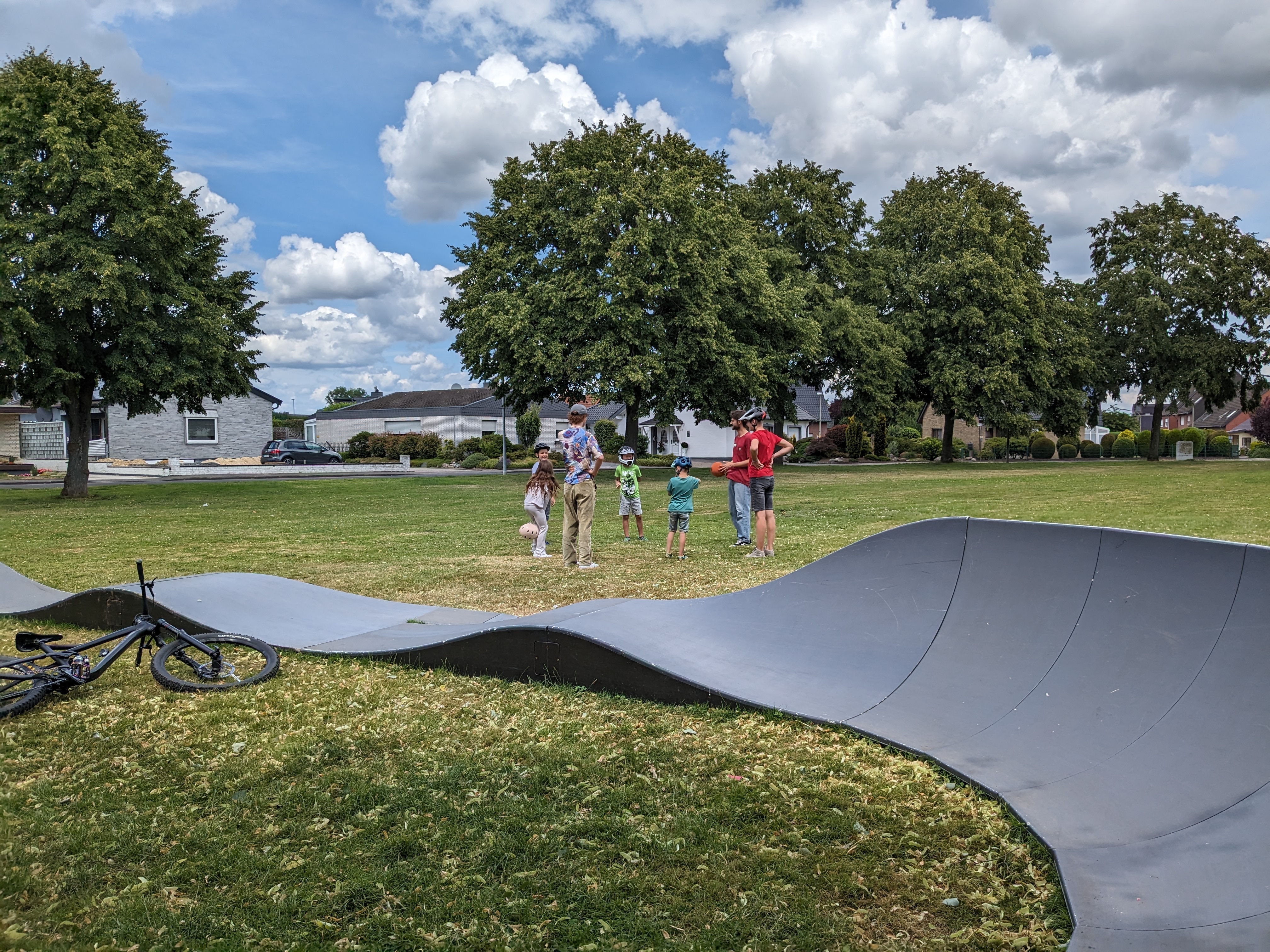 Pumptrackanlage mit Kindern im Hintergrund