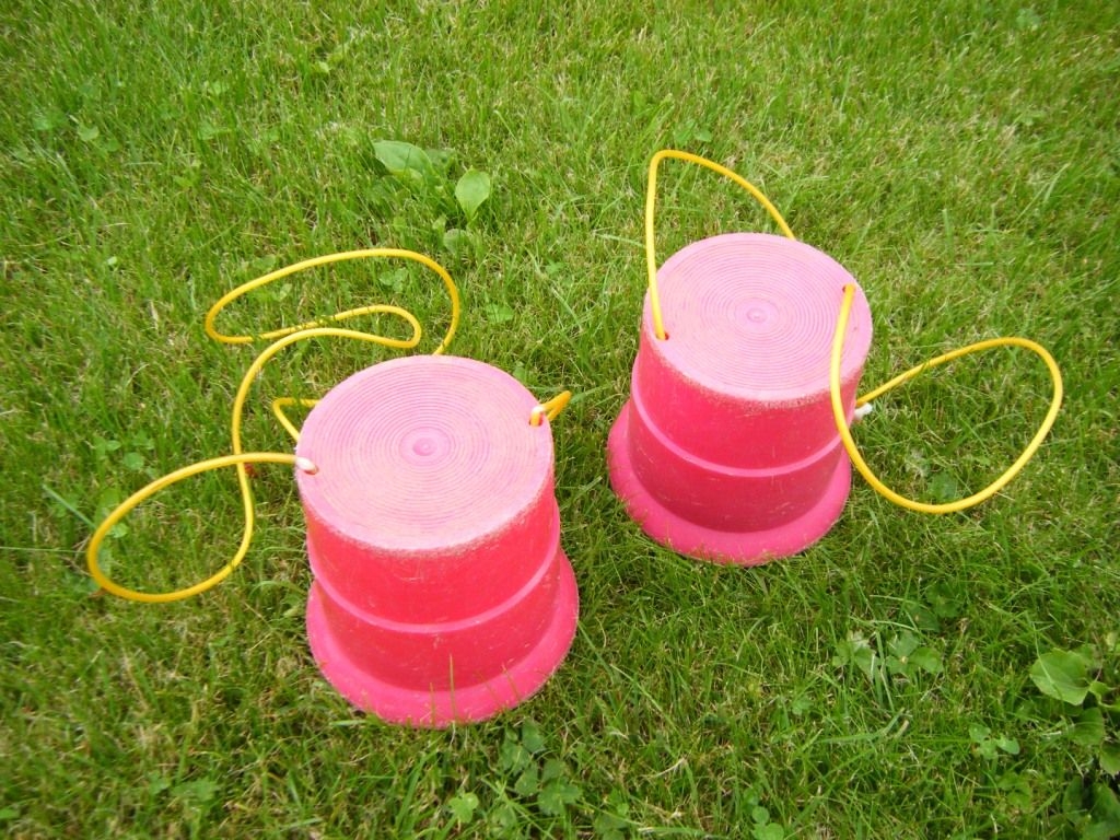 Laufdosen / Stelzenrollen  (auch "Dosenstelzen" oder "Walzenstelzen"): Stelzenrollen aus PVC (zylindrische Kunststoffdosen) mit verstärktem Laufrand und Kunststoff-Griffseil zum Festhalten, 12 cm hoch.
