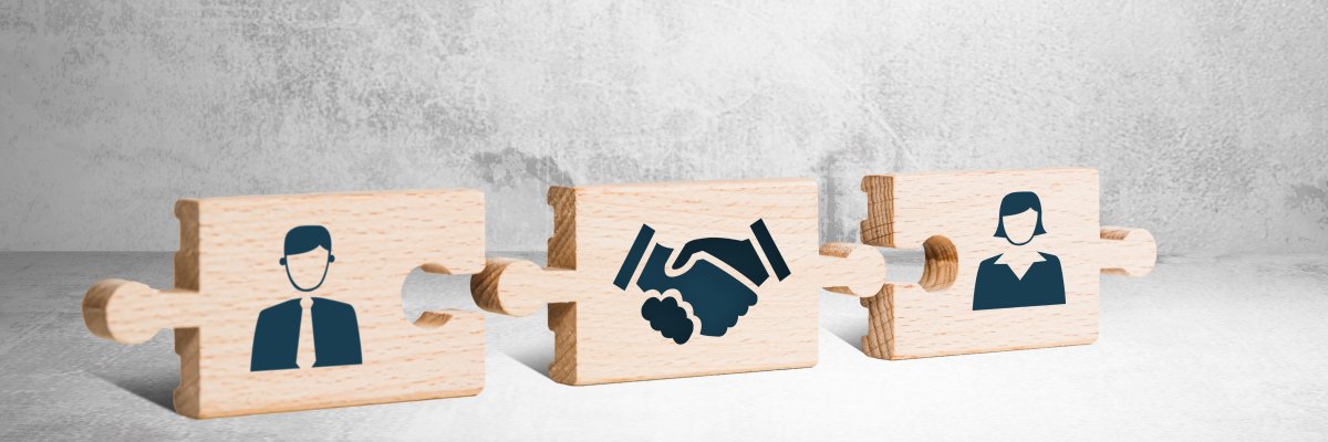 Puzzleteile mit zwei Figuren und Händen, die gedrückt sind