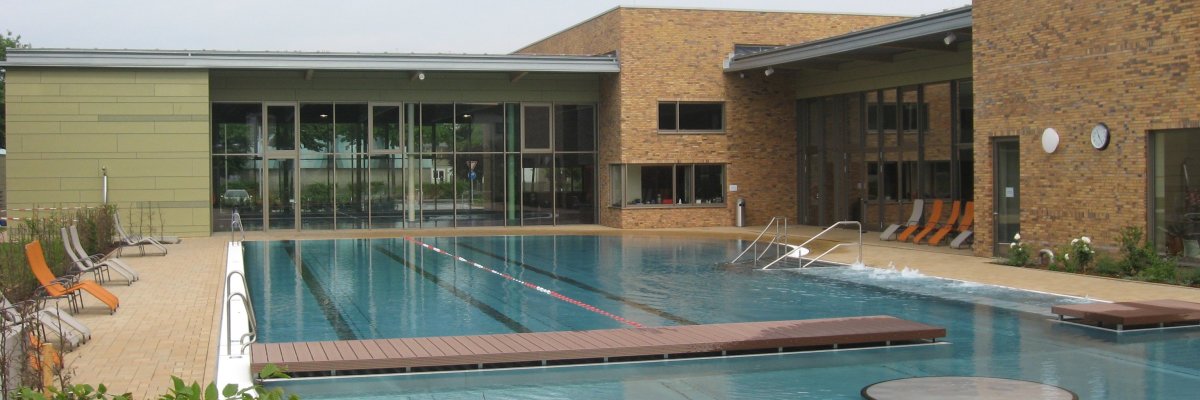 Das Außenbecken des Erka-Bades und die Sonnenliegen am Rand des Beckens ohne Besucher*innen.