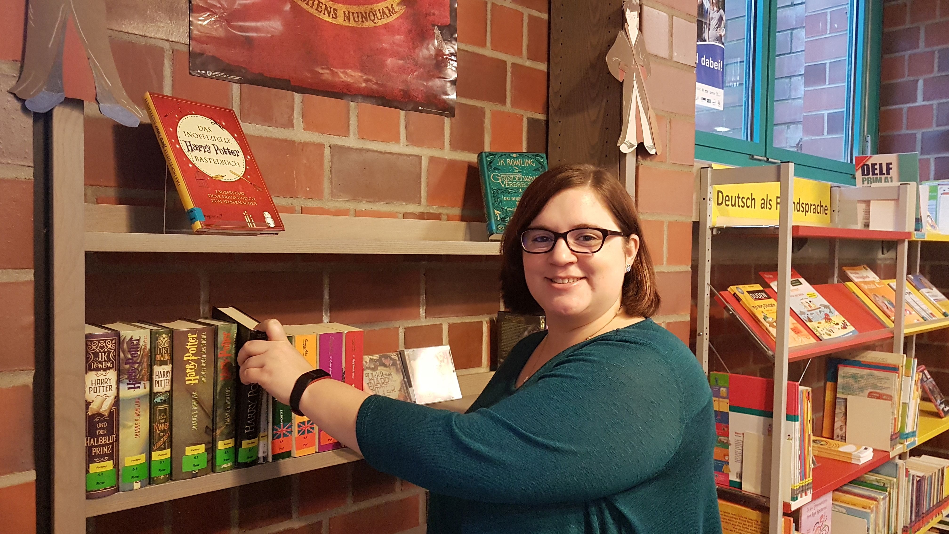Nicole Schulz Nicole Schulz, Mitarbeiterin in der Stadtbücherei, steht an einem Bücherregal