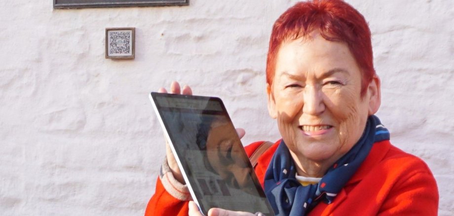 Rita Hündgen, Vorsitzende des Heimatvereins, hält ein Tablet in der Hand