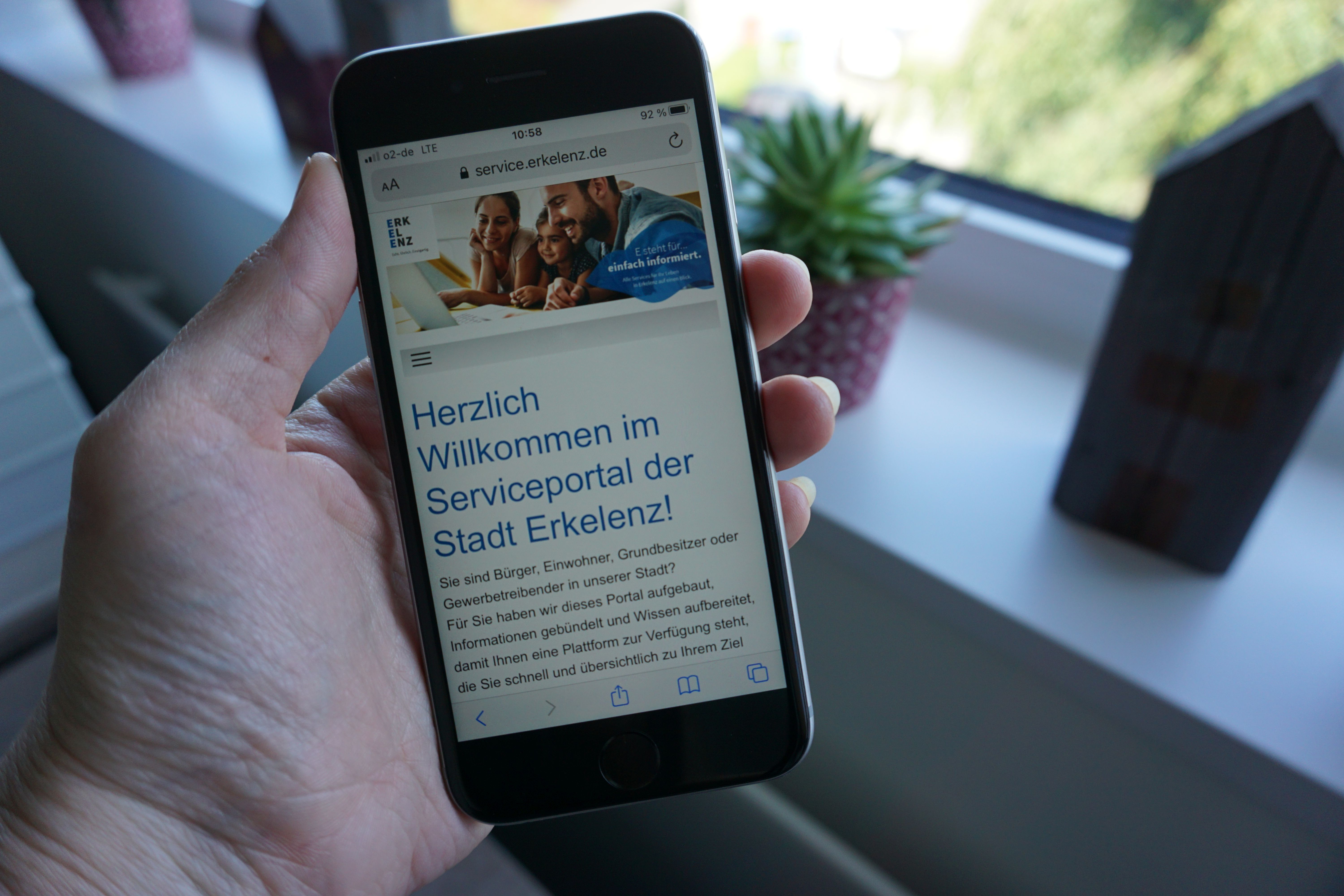 Jemand hält ein Smartphone in der Hand. Geöffnet ist die Seite Serviceportal der Stadt Erkelenz.