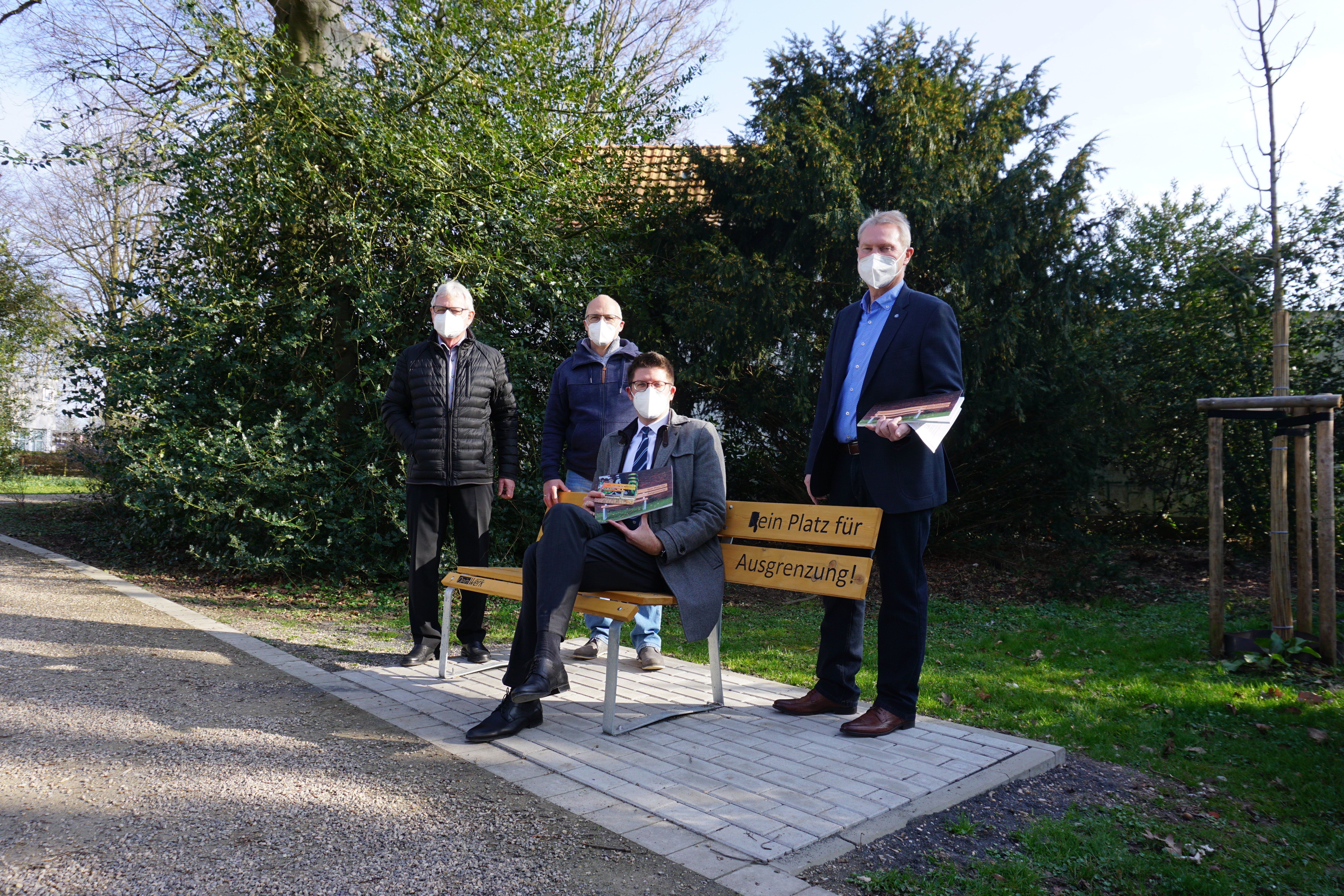 Bürgermeister Stephan Muckel und drei weitere Herren an einer "Bank gegen Ausgrenzung"