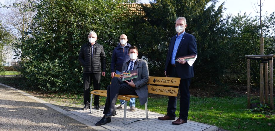 Bürgermeister Stephan Muckel und drei weitere Herren an einer "Bank gegen Ausgrenzung"