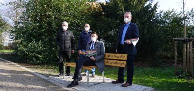 Bürgermeister Stephan Muckel und drei weitere Herren an einer "Bank gegen Ausgrenzung"