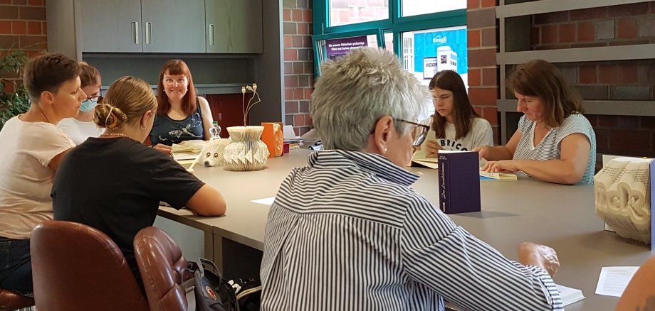 Menschen basteln Kreatives aus alten Büchern beim 1. Workshop im KreativRaum der Stadtbücherei Erkelenz.