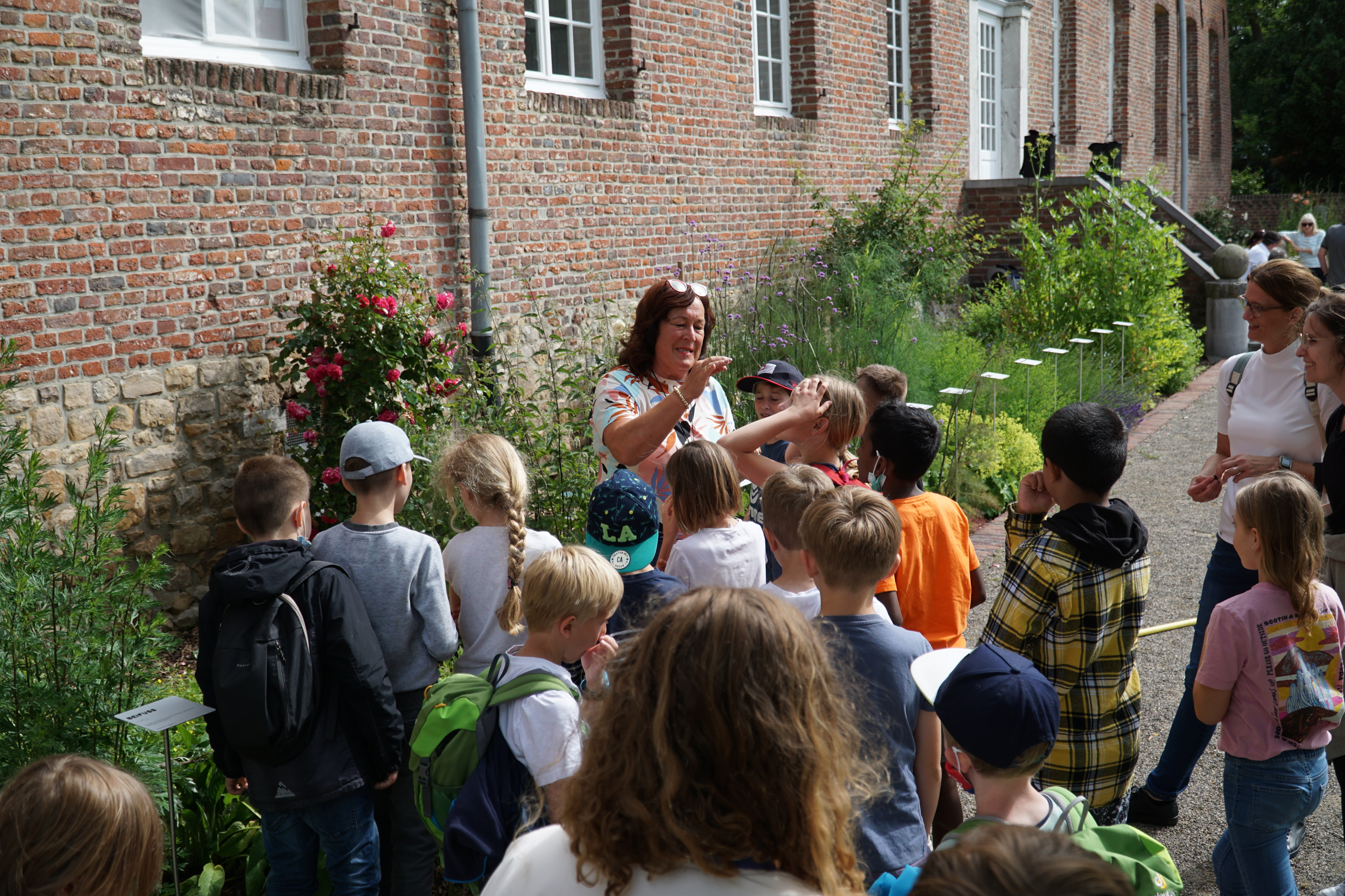 Den Kindern wird etwas zum Hohenbuscher Kräutergarten erklärt.