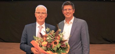 Bürgermeister Stephan Muckel gratuliert Herrn Dr. Hans-Heiner Gotzen mit einem Blumenstrauß zu dessen Wiederwahl zum Ersten Beigeordneten