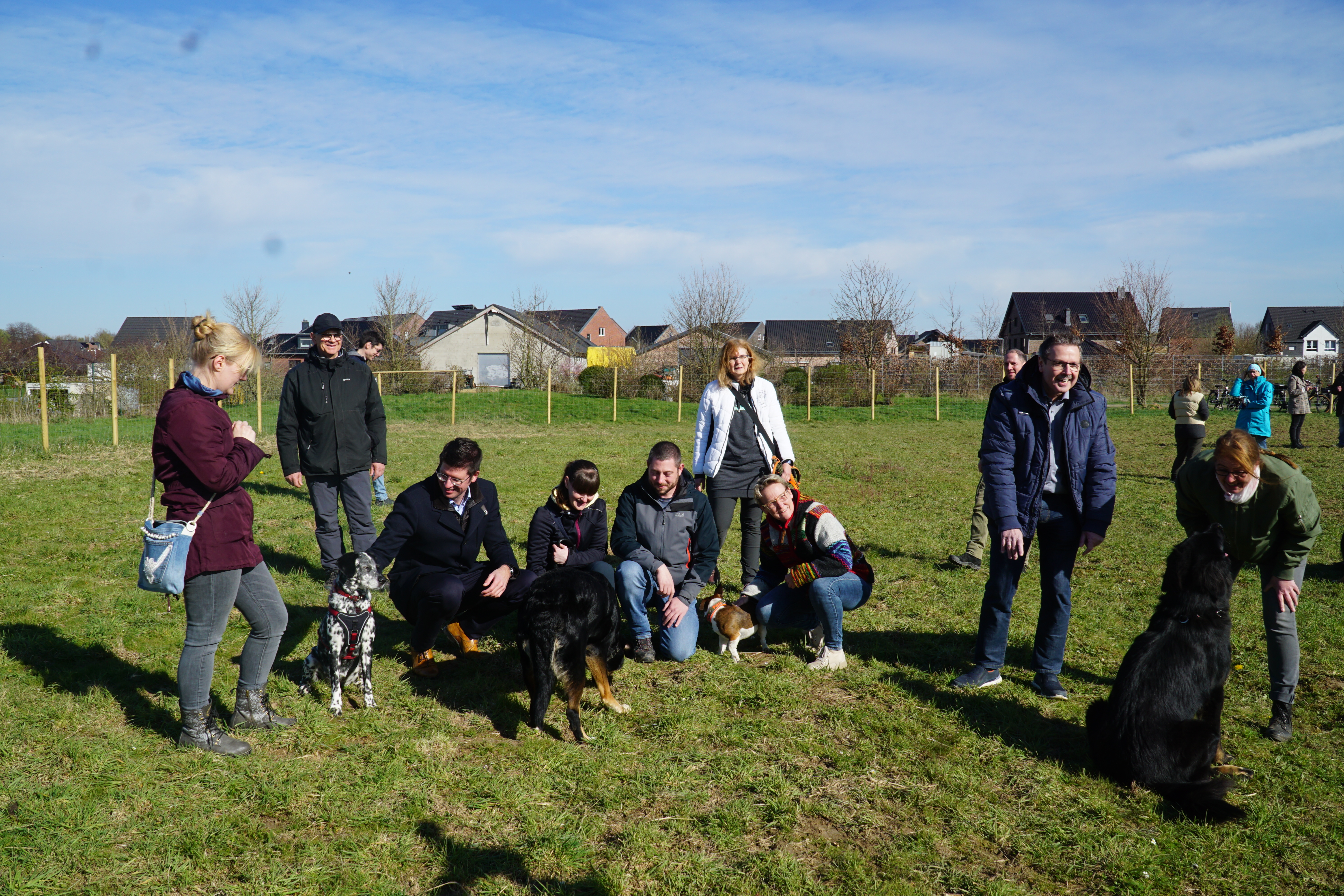 Bürgermeister Stephan Muckel mit Hunden und Hundebesitzern auf der Hundewiese.
