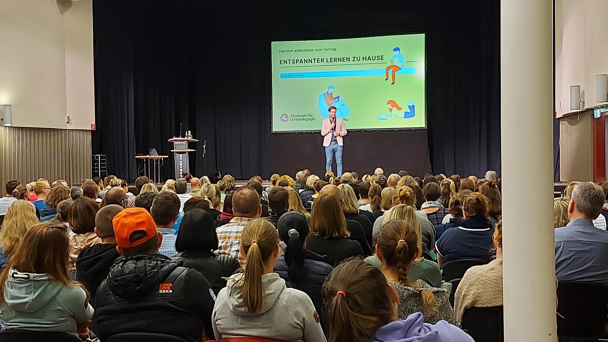 Stadthalle voller Menschen mit Blick auf Präsentation
