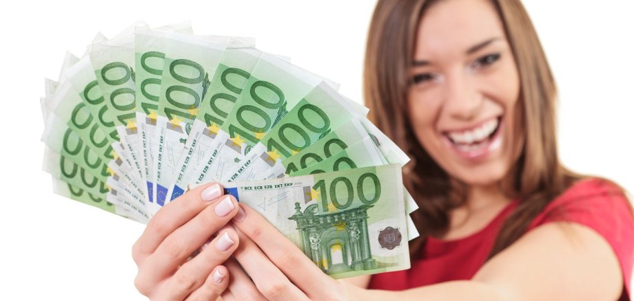 Eine Frau hält viele Hundert-Euroscheine in den Händen