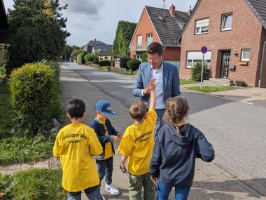 Bürgermeister Stephan Muckel mit Kinder der Astrid-Lindgren-Schule beim Verteilen von Zetteln an falsch Parkende