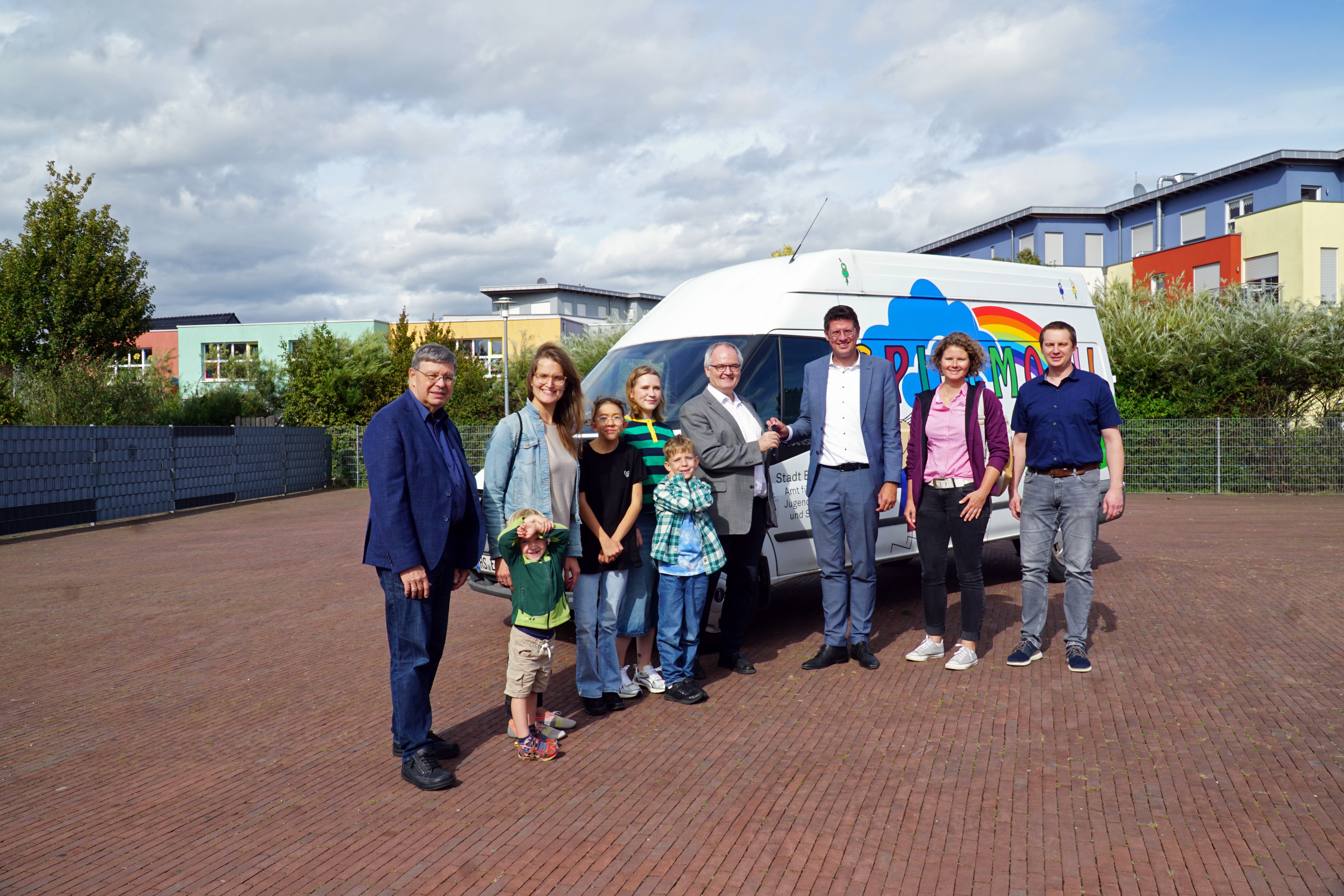 Gruppenbild während der Übergabe des alten Spielmobils, unter anderem mit Bürgermeister Stephan Muckel und Pfarrer Günter Jentges