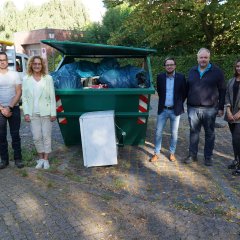 Gruppenfoto zum Abschluss der Aktion vor dem gefüllten Müllcontainer