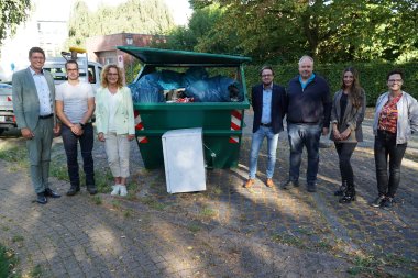 Gruppenfoto zum Abschluss der Aktion vor dem gefüllten Müllcontainer