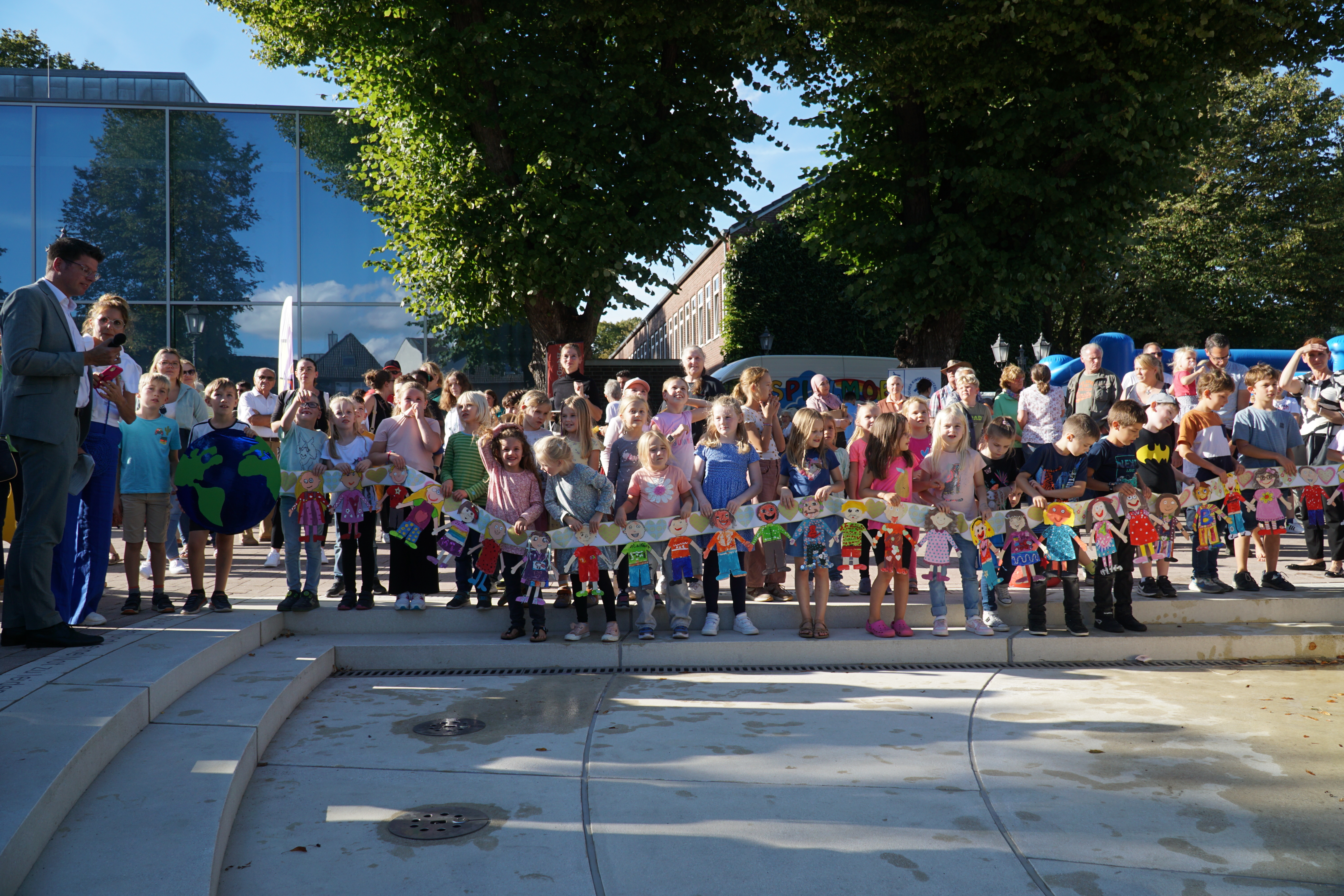 Kinder des Offenen Ganztags an der Luise-Hensel-Schule zeigen eine selbstgebastelte Menschenkette.