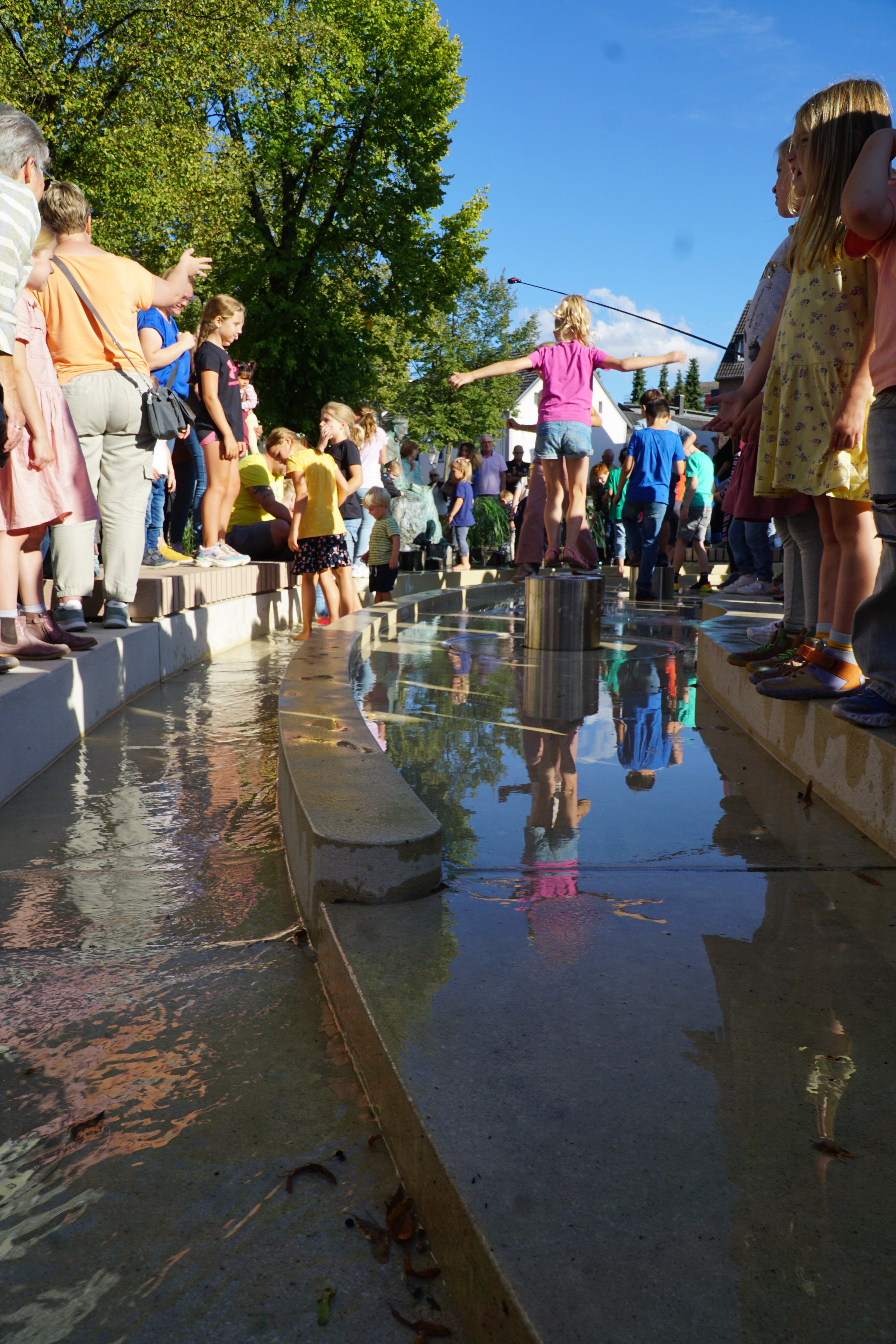 Kinder stehen im Wasserlauf