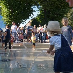 Kinder spielen mit den kleinen Wasserfontänen am Franziskanerplatz