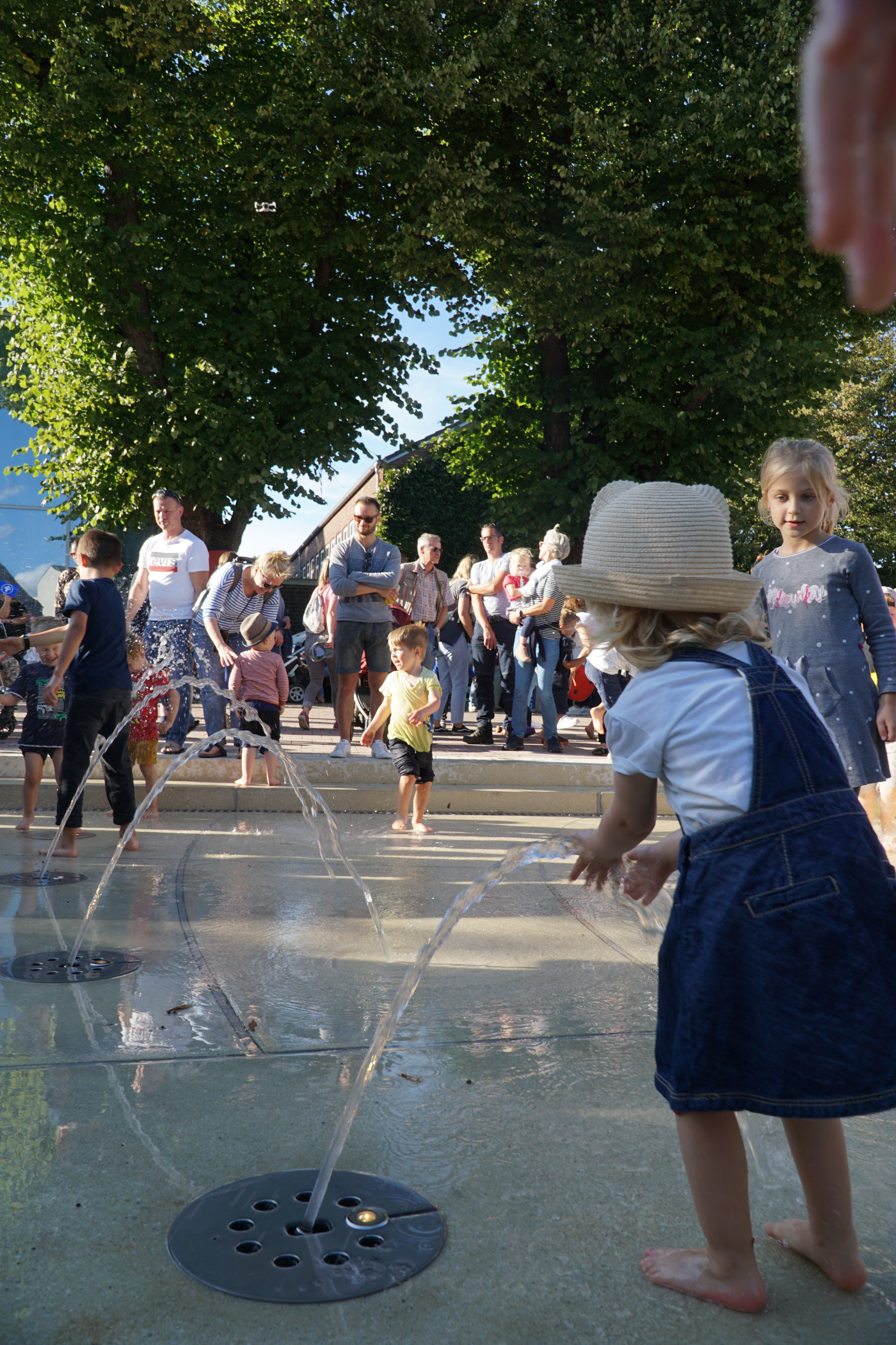 Kinder spielen mit den kleinen Wasserfontänen am Franziskanerplatz
