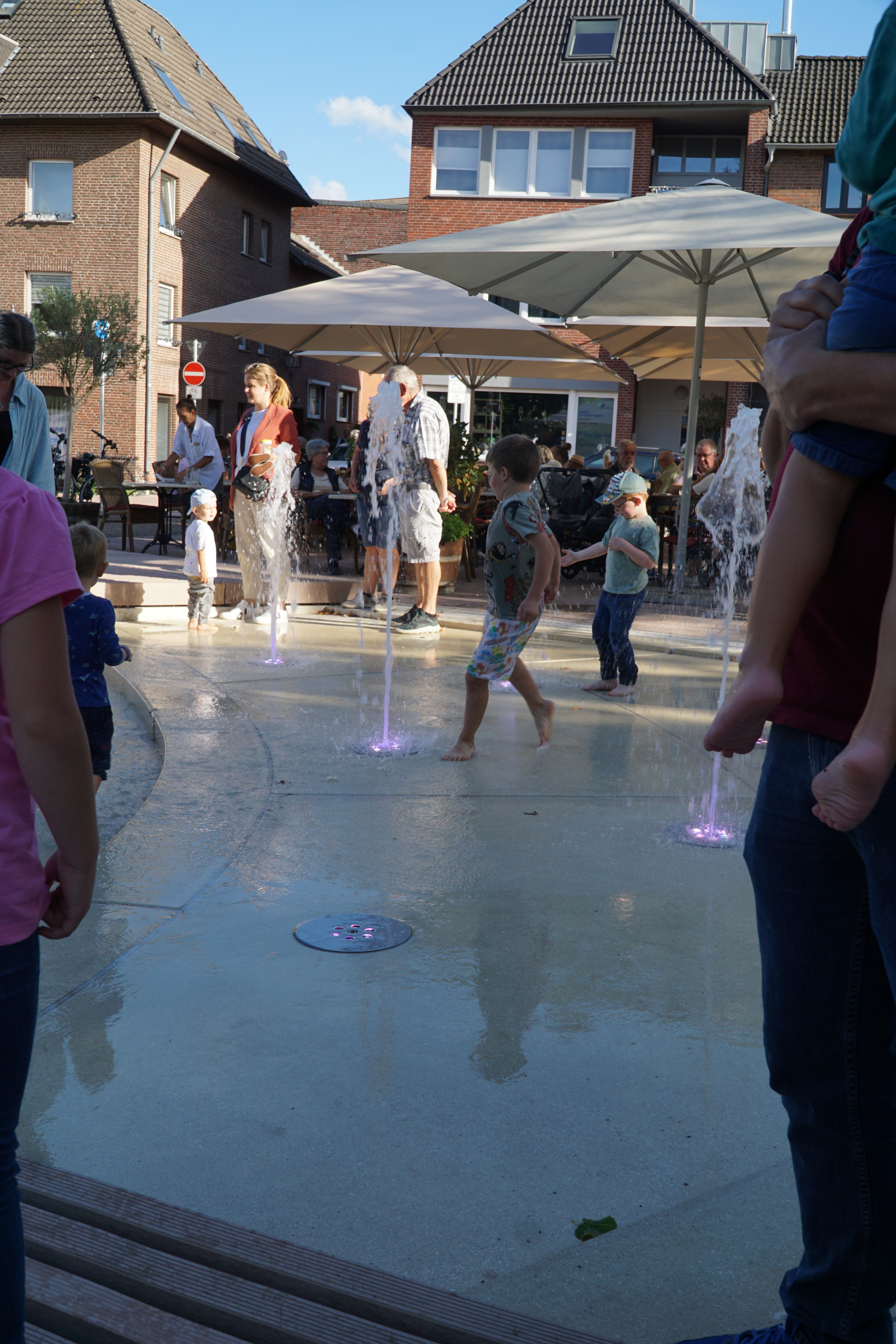 Kinder spielen mit den großen Wasserfontänen am neuen Franziskanerplatz