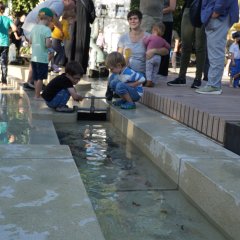 Kinder probieren die Wassersperre im Wasserspiel aus