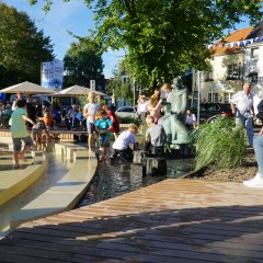 Kinder spielen an der Franziskanerstatue.