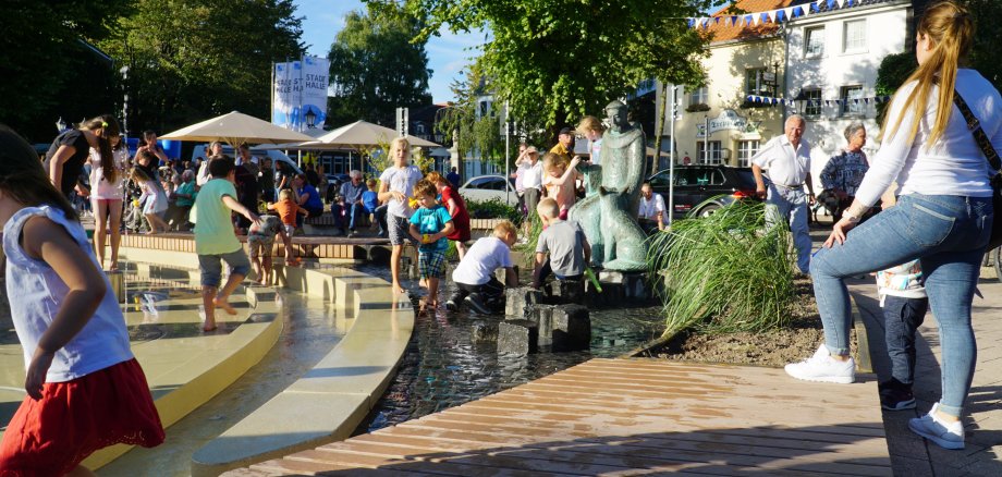 Kinder spielen an der Franziskanerstatue.