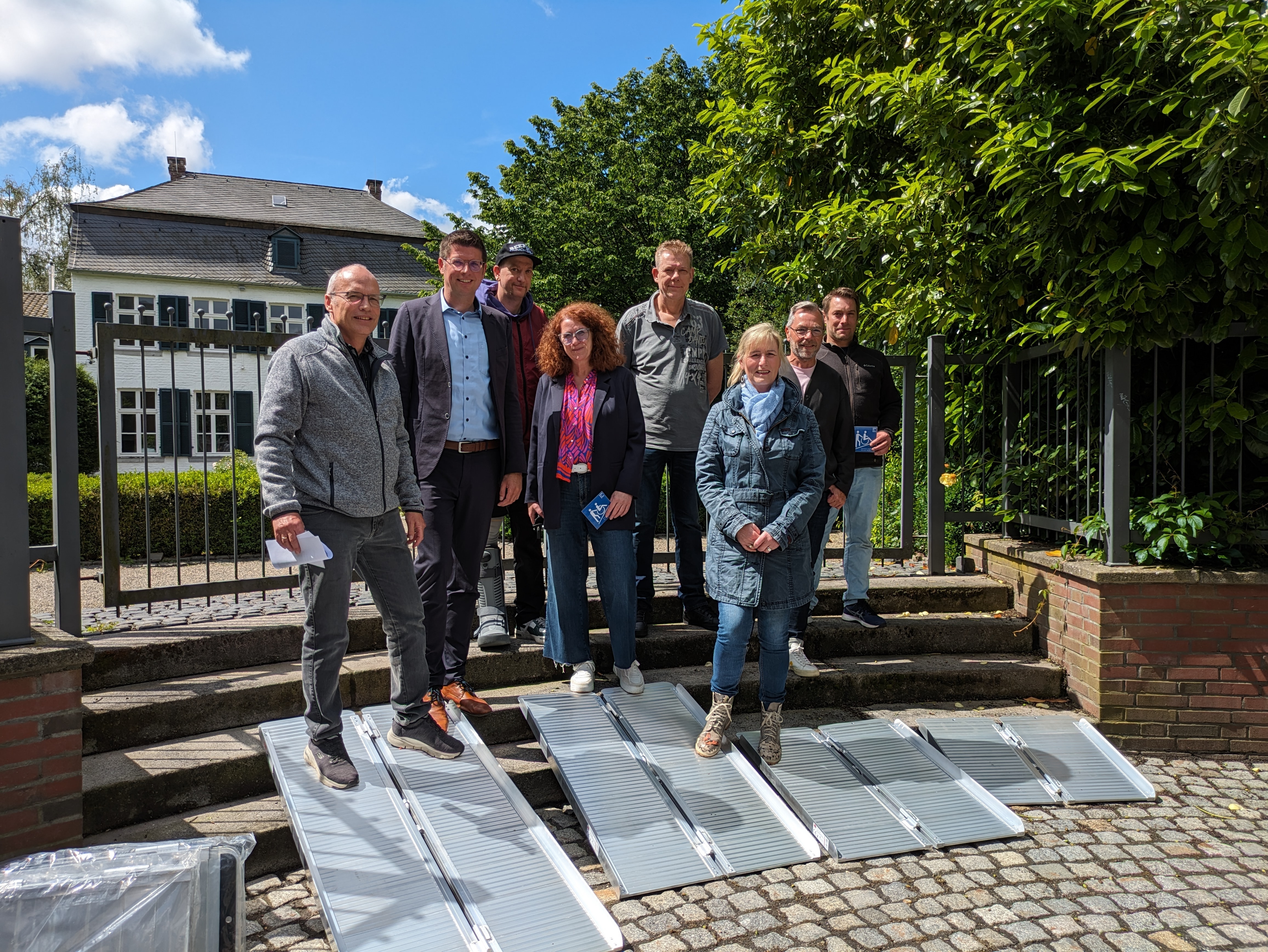 Von links nach rechts:  Andreas Ullmann (ehrenamtlicher Behindertenbeauftragter), Bürgermeister Stephan Muckel, Dennis Gang (Copy Garden), Andrea Funk (Funk), Jür-gen Giese (Bier & Caféhaus), Karin Masuch (Stadtmarketing), Stefan Herzog (Jaegers & Klingenhäger) und Simon Pietras (Copygarden) bei der offiziellen Übergabe der sieben neuen Rollstuhlrampen.