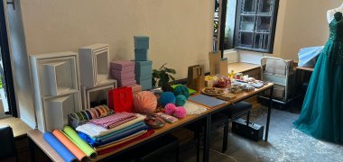 verschiedene Materialien für eine ansprechende Schaufenstergestaltung liegen auf einem Tisch
