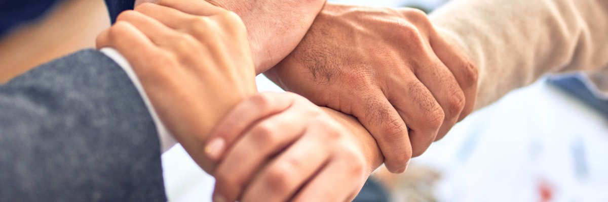 Vier Hände, die einander festhalten