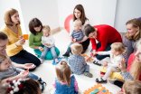 Kleinkinder mit Erwachsenen in einem Sitzkreis