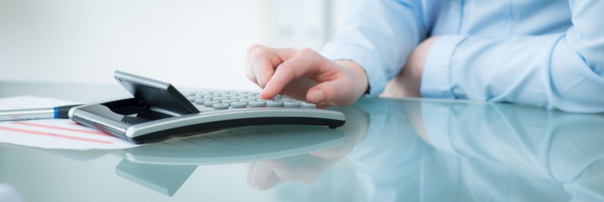 Ein Mann tippt auf einem Taschenrechner.