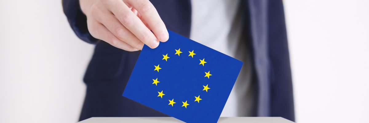 Mann wirft ein Blatt mit Europafahne in eine Wahlurne