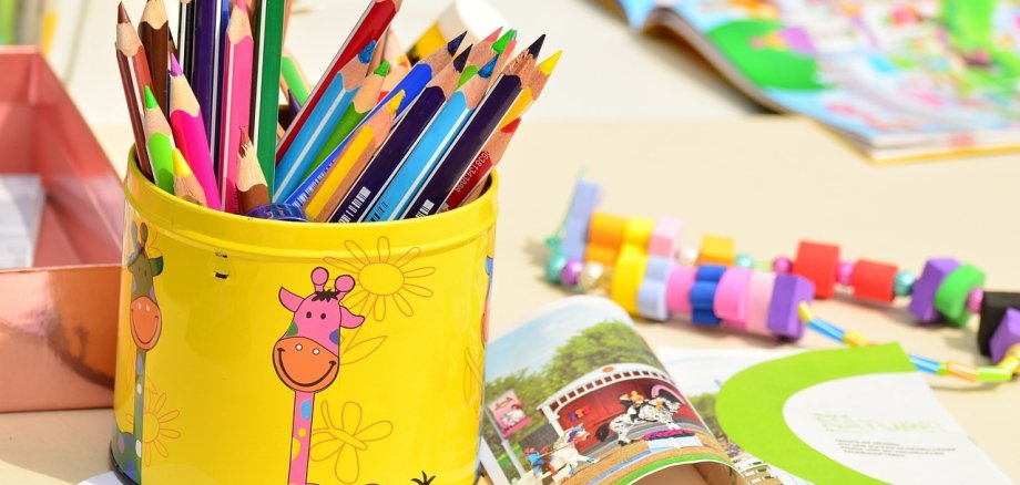 Buntstifte in Metallbox und Kinderspielzeug